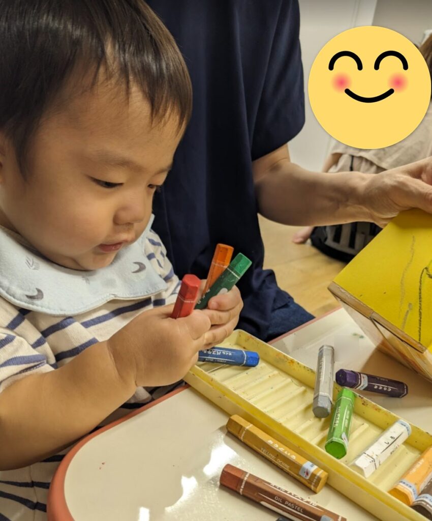 保育園でクレヨンで絵をかいて遊ぶ我が子